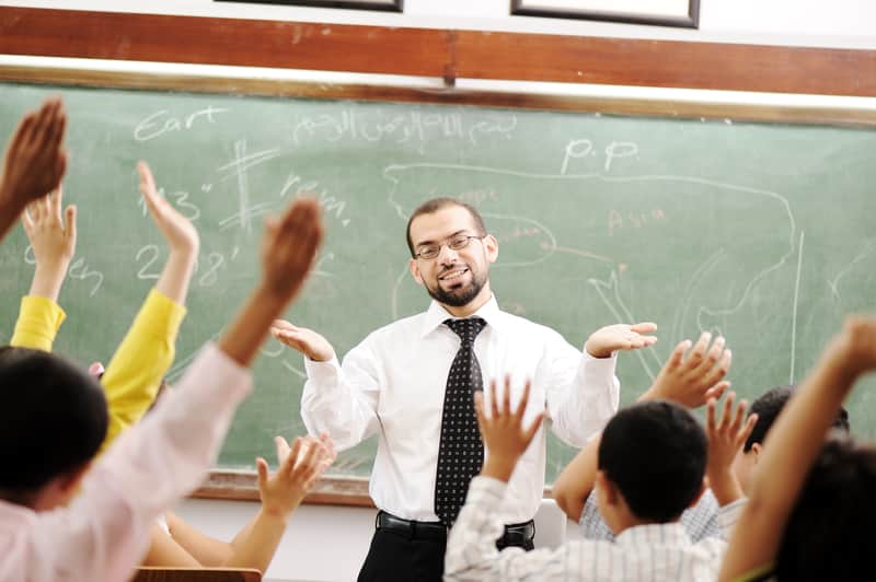 male teacher at the front of a classroom