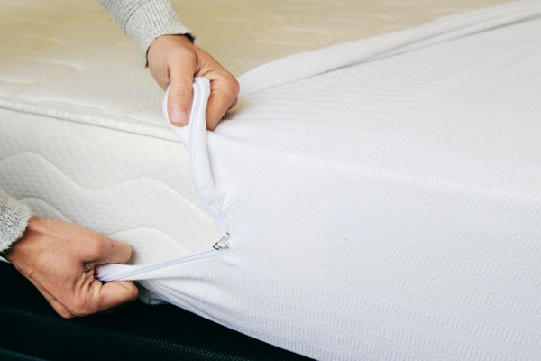 A white mattress encasement over a white mattress.