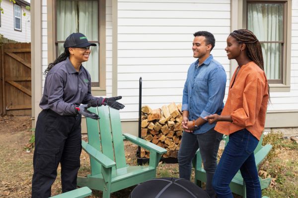 terminix tech talking to customers outside house