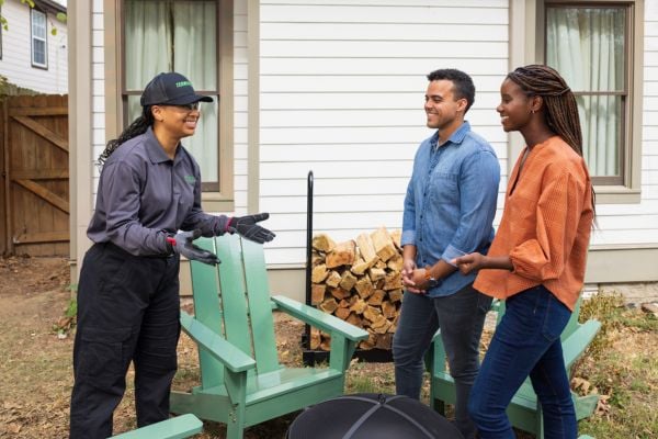 terminix tech talking to customers outside house