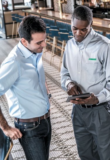 Inspector shows restaurant manager the results of an inspection