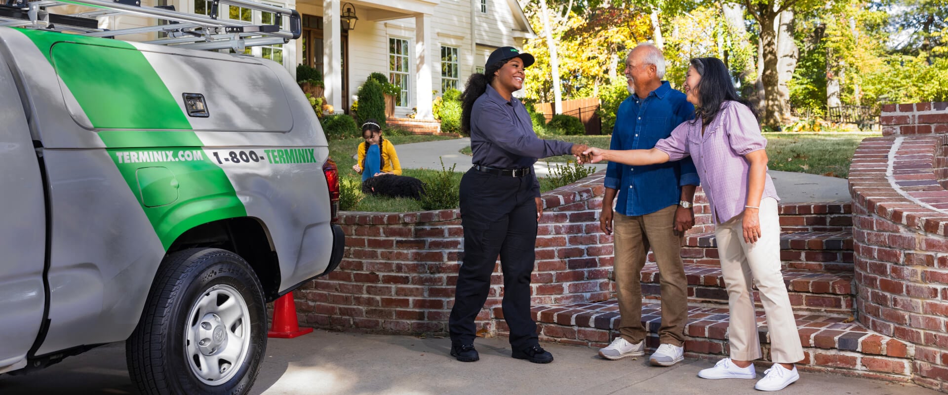 Terminix technician shaking hands with home owners