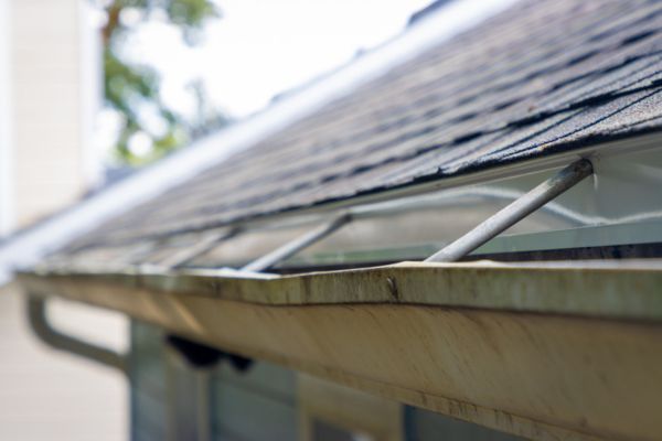 Close-up of clean roof gutter protection installed along an asphalt shingle roofline